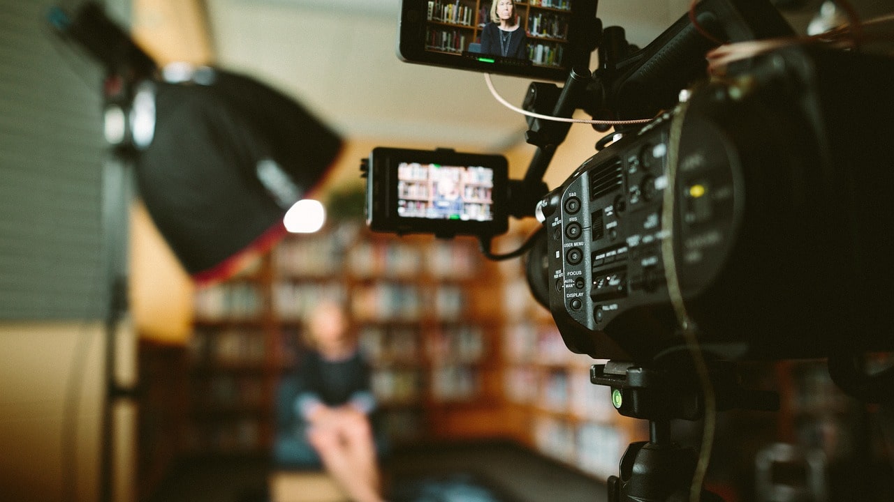 Home-Video-Studio-Blog-Header-Woman-Sitting-in-Front-of-Bookshelf