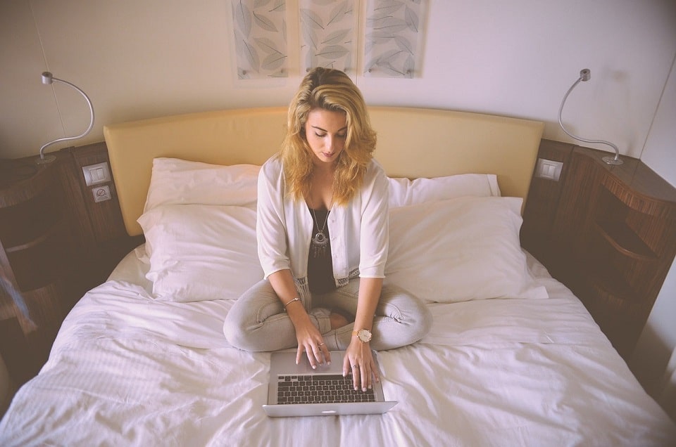 Digital Business From Home Woman Typing on Laptop In Bed