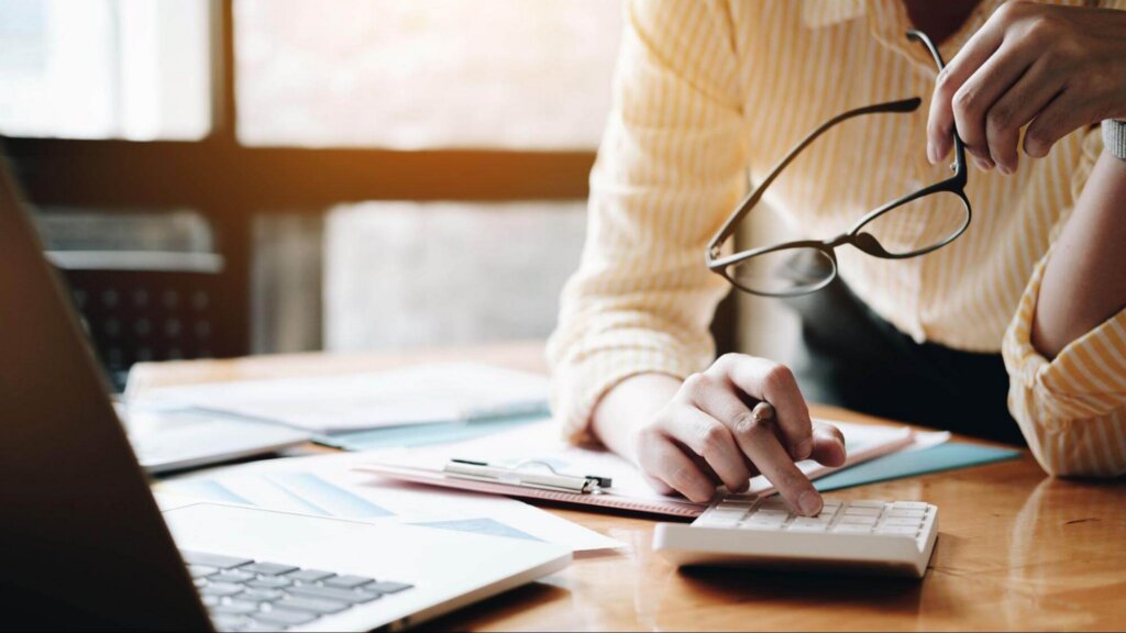The Hidden Cost of Financial Inaction Woman Typing Into Calculator